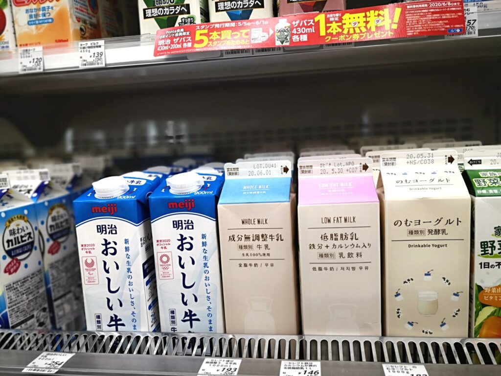 明治「おいしい牛乳」（左）とノンブランドの成分無調整牛乳（中）のパッケージ